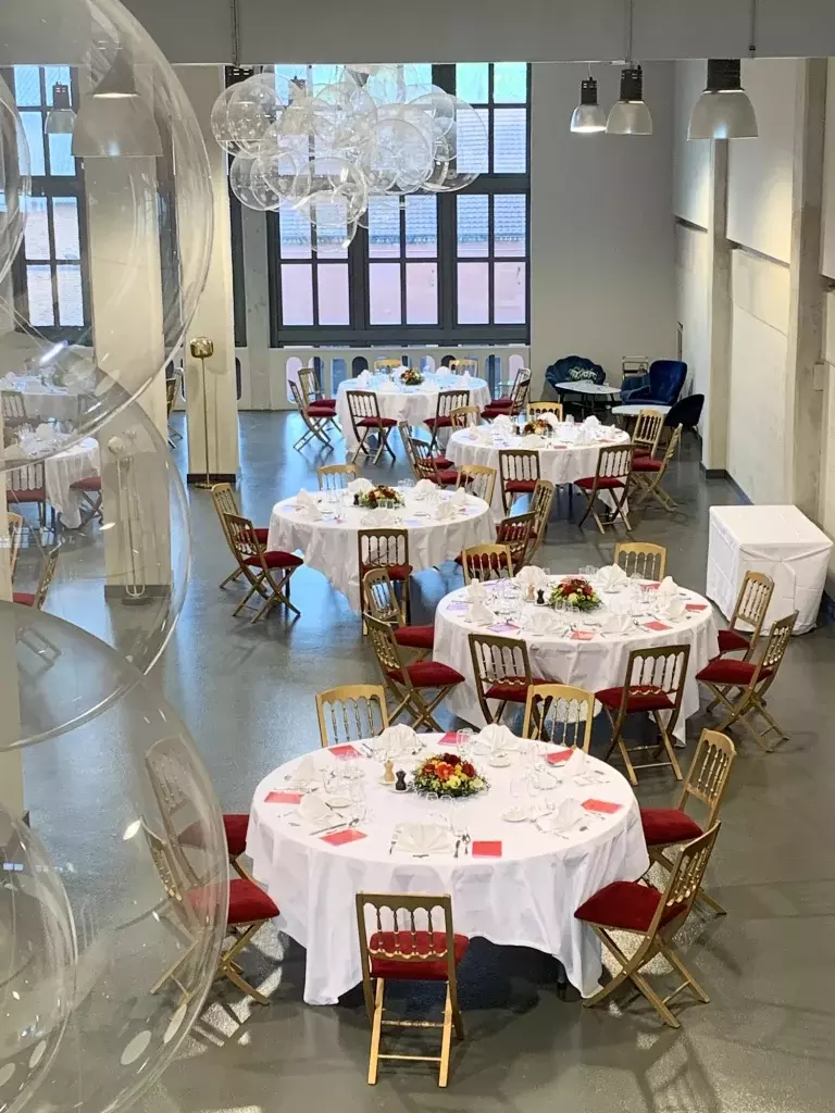 Salle de réception dressée avec des tables rondes